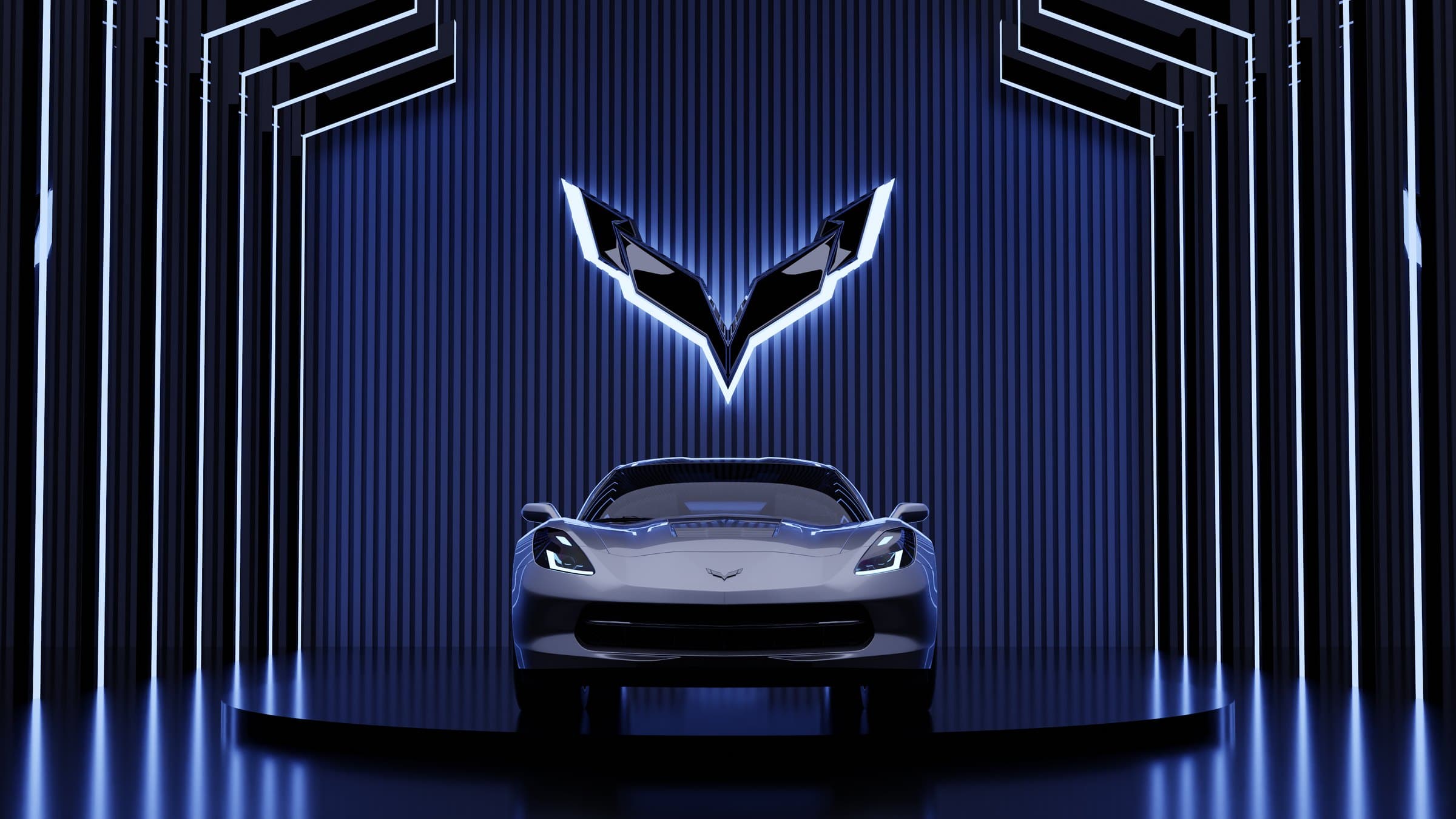 A silver Corvette facing the camera in a dark studio lined with vertical blue light strips, the Corvette emblem glowing above.